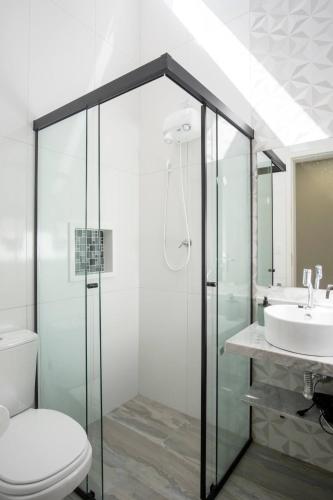 a bathroom with a shower and a toilet and a sink at Villa da Serra 1 in Paraty