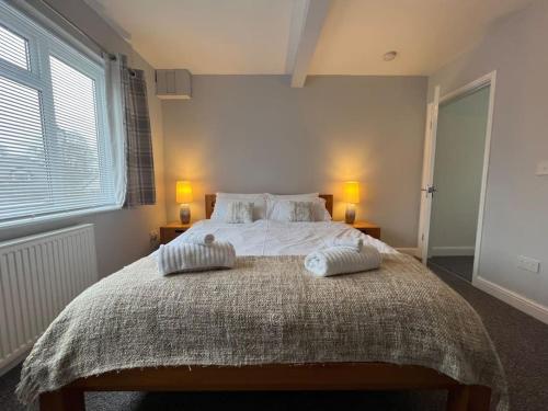 a bedroom with a large bed with two pillows on it at Ground floor flat with parking, sleeps 3 in Wheatley