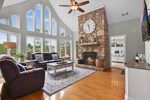 a living room with a fireplace and a clock at Lily's Lookout Lodge - Helen, GA in Helen