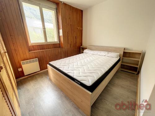 1 dormitorio con 1 cama en una habitación con ventana en Appartement 15, 4 couchages, en Aulus-les-Bains