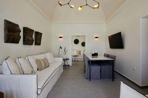 a living room with a white couch and a desk at Lerion Luxury Villas in Akrotiri