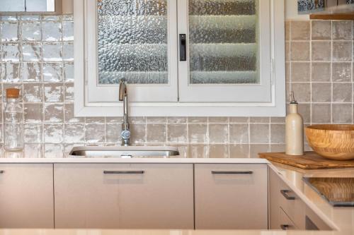 a kitchen with white cabinets and a sink at Flateli Sant Antoni 6 in Calonge