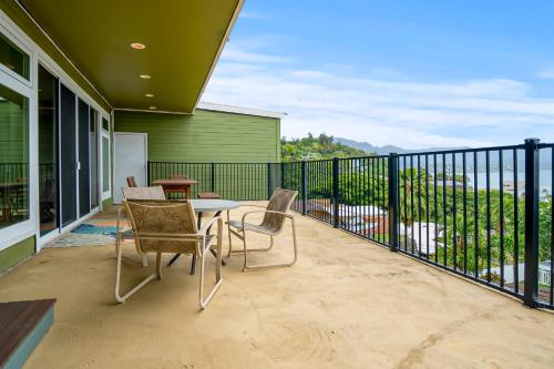 a patio with a table and chairs on a balcony at Ka Hale me Ka ike 30 Night Minimum in Kaneohe