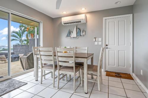 a dining room with a table and chairs and a window at Ka Hale me Ka ike 30 Night Minimum in Kaneohe