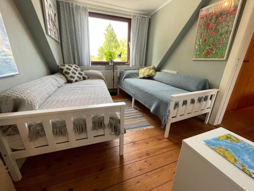 mały pokój z 2 łóżkami i oknem w obiekcie Ferienhaus Jenny w mieście Flensburg
