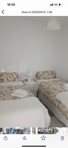 two beds sitting next to each other in a bedroom at Casa con piscina privada in El Puerto de Santa María
