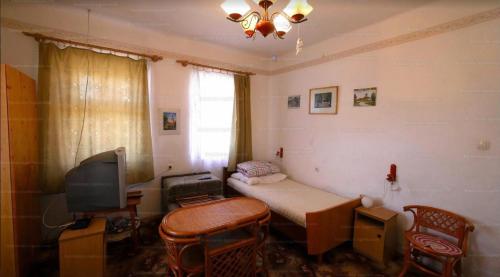 Cette petite chambre comprend un lit et une télévision. dans l'établissement Tornácos Vendégház - Kismarja, à Kismarja