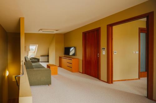 a living room with a couch and a television at Park Holiday Congress & Wellness Hotel in Prague