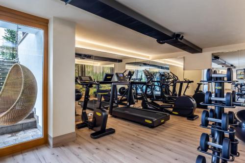 a gym with several treadmills and elliptical machines at Hotel Nordik Adults Only - Over 14 in Andalo