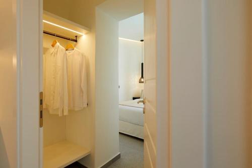 a bathroom with a closet with a mirror and a robe at Lerion Luxury Villas in Akrotiri