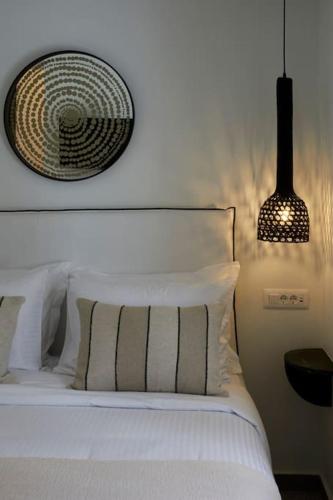 a bedroom with a white bed with a picture on the wall at Lerion Luxury Villas in Akrotiri
