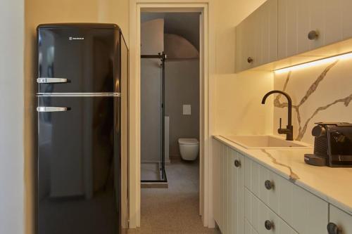 a bathroom with a black refrigerator and a sink at Lerion Luxury Villas in Akrotiri