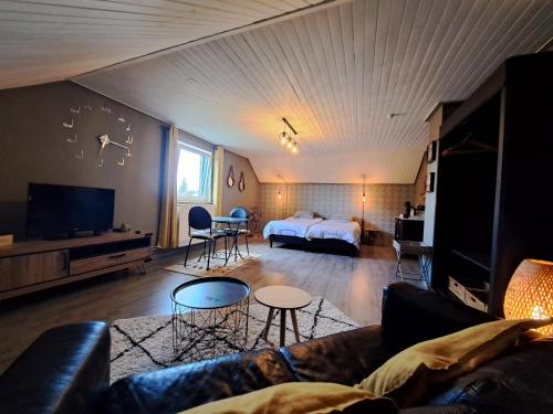 Chez Baf - Wibrin - Houffalize في Wibrin: غرفة معيشة مع أريكة وسرير