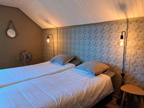 sypialnia z 2 łóżkami i 2 lampkami na ścianie w obiekcie Chez Baf - Wibrin - Houffalize w mieście Wibrin