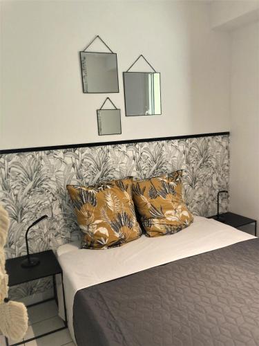 un lit avec des oreillers et un mur avec deux miroirs dans l'établissement brise marine, à Les Sables-dʼOlonne