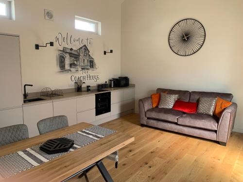 a living room with a couch and a table at Executive Coach House on the Hoe 2 free parking spaces in Plymouth