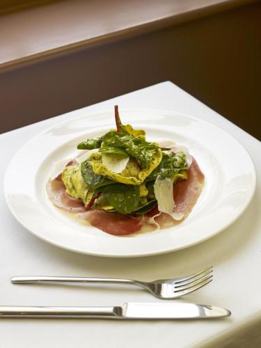 a plate of food on a table with a fork and knife at Sydney House Chelsea in London
