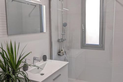 uma casa de banho branca com um lavatório e um espelho em 3 pièces dans villa avec piscine em Nice