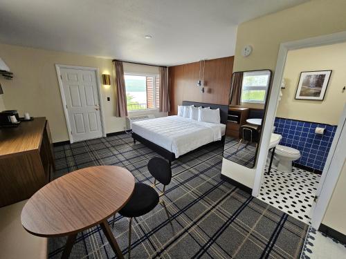 a hotel room with a bed and a table and chairs at The Hotel Laurel at Seneca in Watkins Glen