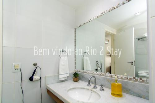 y baño con lavabo y espejo. en Verano Stay suíte 5 ( Arena e Parque Olimpico), en Río de Janeiro