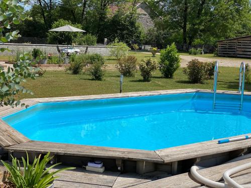 ein Pool in einem Garten neben einem Hof in der Unterkunft Le Ronsard in Blye