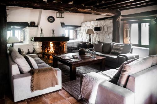 sala de estar con sofás, mesa y chimenea en Molino del Feo, en Las Casas Altas