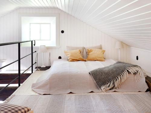 biała sypialnia z dużym łóżkiem na poddaszu w obiekcie Holiday home HOVA V w mieście Hova
