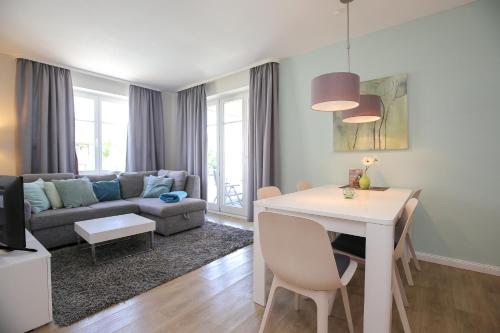 a living room with a white table and a couch at Dünenblick Wohnung 09 in Boltenhagen