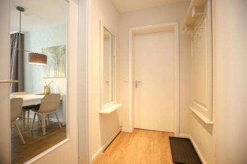 a white room with a table and a dining room at Dünenblick Wohnung 09 in Boltenhagen