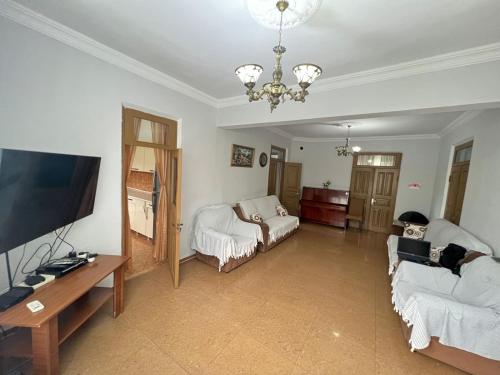salon z telewizorem z płaskim ekranem i kanapą w obiekcie Guest House In Gonio w mieście Gonio