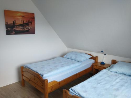 a room with two beds and a picture on the wall at Apartment an den Teichen in Lengede