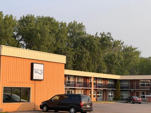 an orange building with a van parked in front of it at Devils Lake Inn in Devils Lake