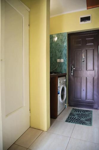 a bathroom with a door and a washing machine at Mieszkanie wynajem in Giżycko