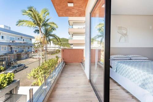 einen Balkon mit einem Bett und Straßenblick in der Unterkunft Casa Neves em Bombas in Bombinhas