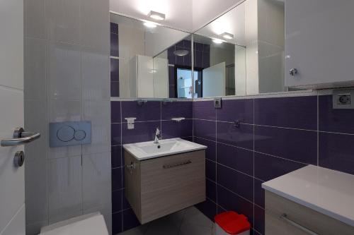 een badkamer met een wastafel en een spiegel bij Waterfront Apartments with Pool in Novalja