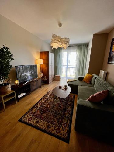 ein Wohnzimmer mit einem Sofa und einem Tisch in der Unterkunft Klimatyczne mieszkanie w centrum Giżycka in Giżycko