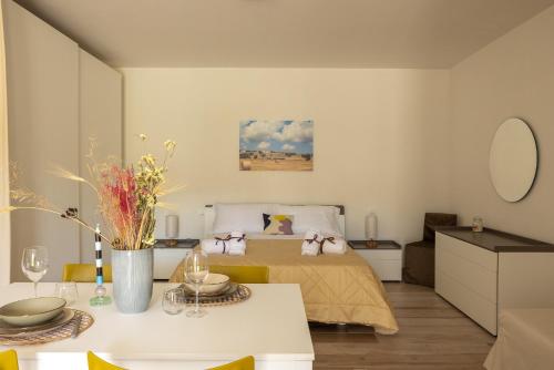a bedroom with a bed and a table with flowers on it at Color Dream Residence in Monopoli