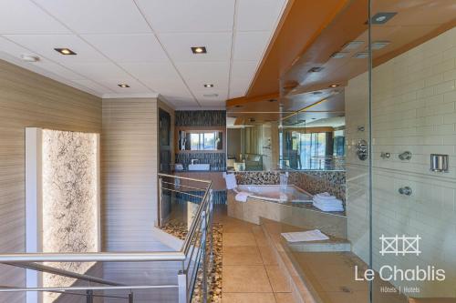 a large bathroom with a tub and a sink at Hotel Le Chablis Cadillac in Montréal