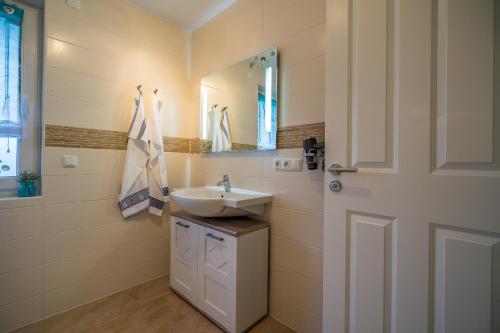 a bathroom with a sink and a mirror and a door at Whg 09 - Fischerstuv in Zingst