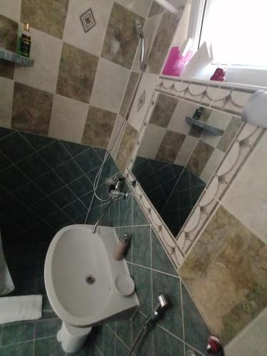 uma casa de banho com um WC e um espelho. em Úrrétje Vendégház em Debrecen