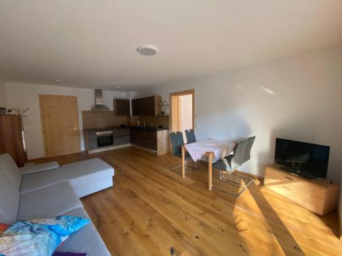 a living room with a couch and a table and a television at moderne Apartments am Attersee Dachsteinblick - ruhige Lage mit traumhaften Blick in Nussdorf am Attersee