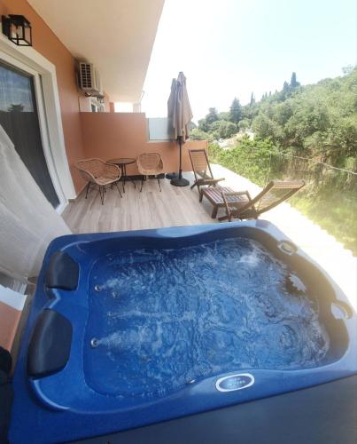 a blue tub in a room with a table and chairs at Stavroula Studios in Paleokastritsa