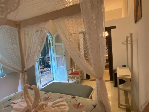 1 dormitorio con 1 cama con cortinas y ventana en LE JARDIN DU FORT - GALLE, en Galle