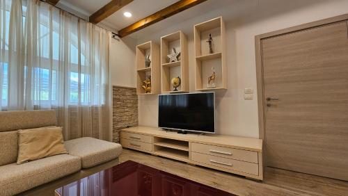 a living room with a flat screen tv on a entertainment center at Villa Umbra et Sol in Gruda