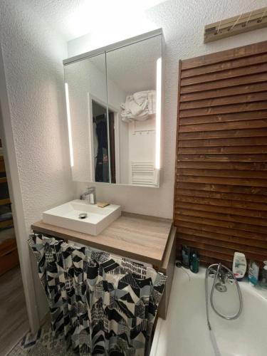 a bathroom with a sink and a mirror and a tub at Bonheur des Orres 1650 in Les Orres