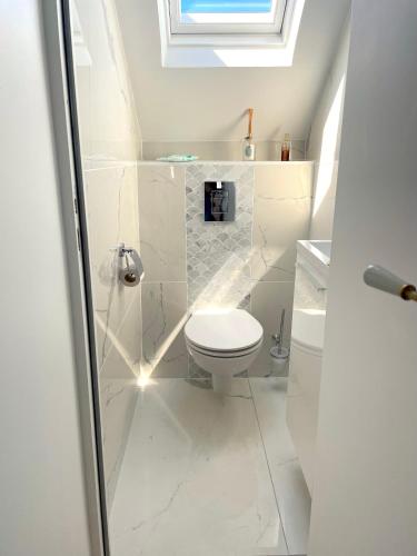 une salle de bain blanche avec des toilettes et un lavabo dans l'établissement Charmant Duplex à 1min La Baule, au Pouliguen