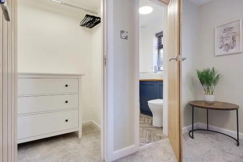 een badkamer met een toilet en een kast met een tafel bij Windham Mews - Stunning Flat in Seaside Town in Bournemouth