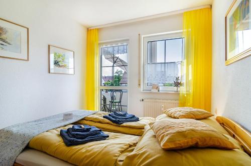 two beds in a room with yellow walls and windows at Relaxen am Illmensee in Illmensee