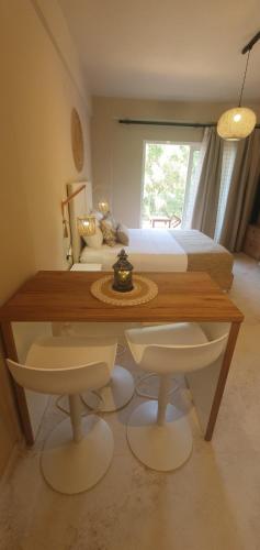 a bedroom with a bed and a table and chairs at Stavroula Studios in Paleokastritsa