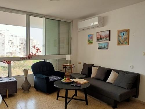 a living room with a couch and a table at Cozy apartment with good vibe in Ashdod